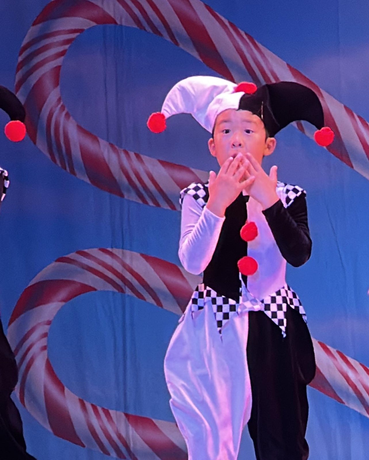 Jian as a Clown in front of a candy cane backdrop, 2022