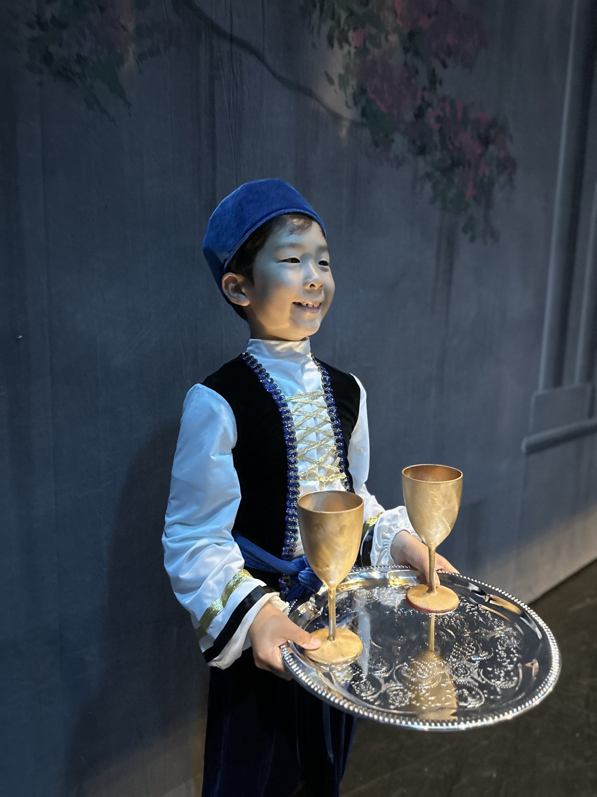 Jian backstage holding a tray with goblets